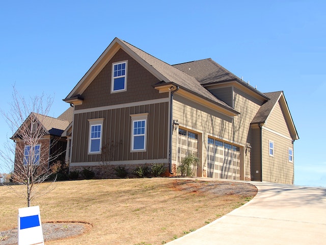 a brown house at the end of a driveway
