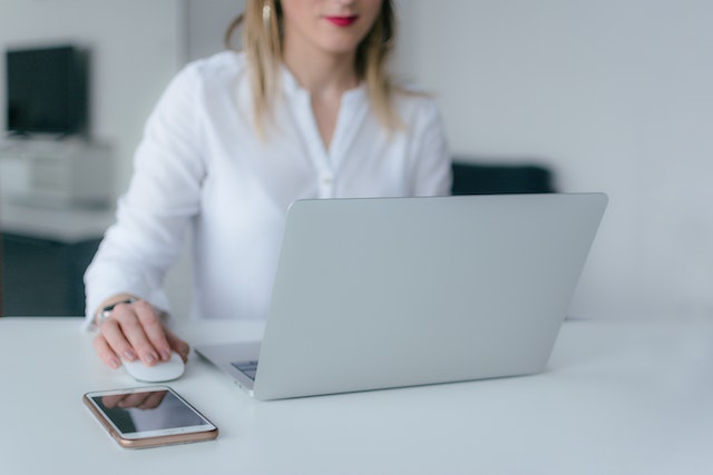 someone using a laptop a next to a phone
