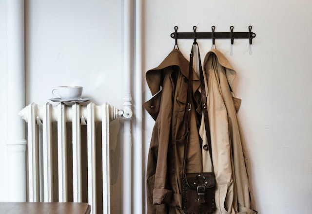 a cup and saucer on a radiator next to jackets