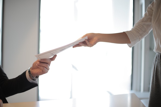 two hands exchanging papers