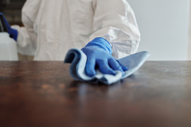 a person in a white suit wiping a surface