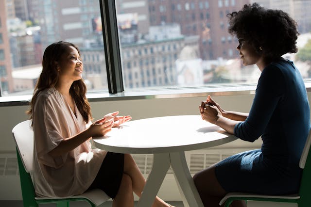 Two people talking over table