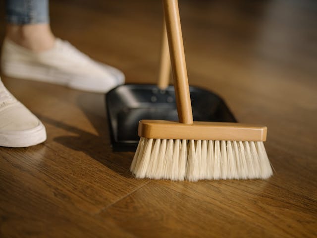 person sweeping into dust pan
